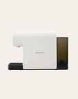 White espresso machine with a black base on a beige background