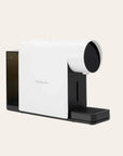 White and black coffee machine on a beige background