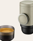 Hand pump espresso brewer for travel on a beige background