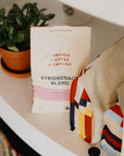 A bag of Strongback Blend sitting on a shelf with a plant.