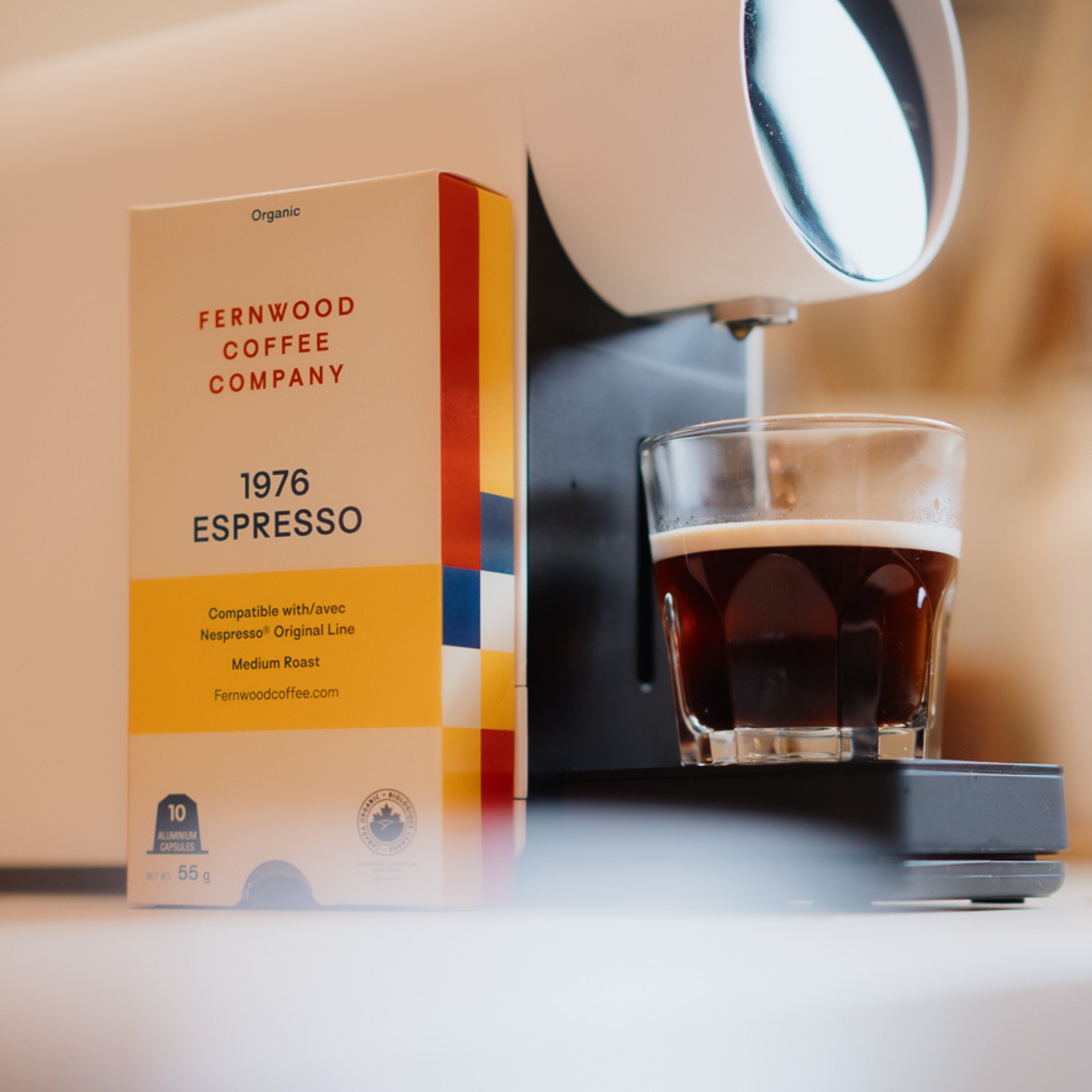 Fernwood Coffee Company 1976 Espresso package next to an espresso machine and glass of coffee.