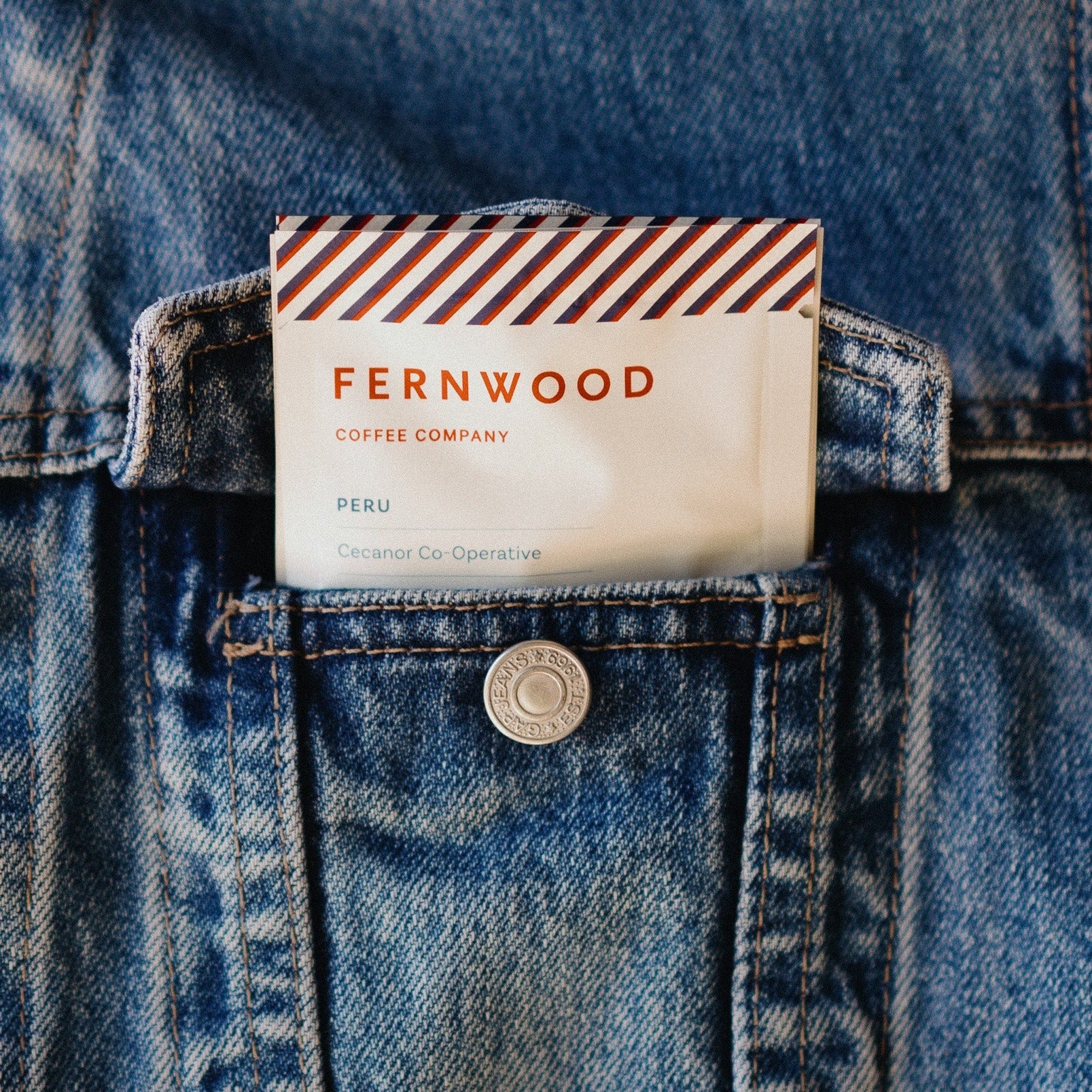 A pouch of Peru Decaf instant coffee sticking out of a pocket.