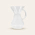 Clear glass Chemex Brewer with handle on a beige background