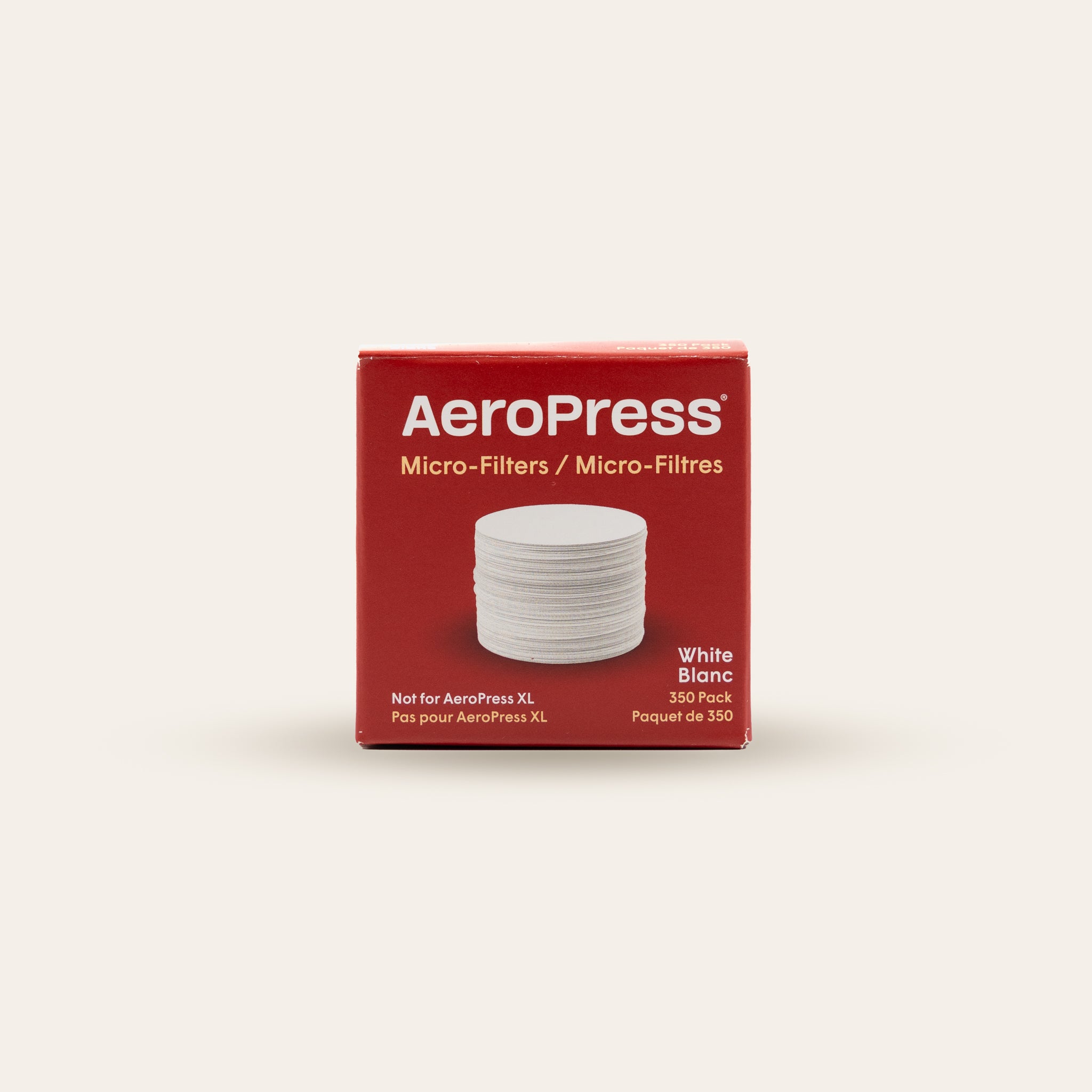 Box of Aeropress  papermicro-filters on a beige background