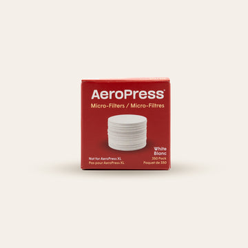 Box of Aeropress  papermicro-filters on a beige background