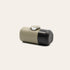Minipresso laying on its side on a beige background