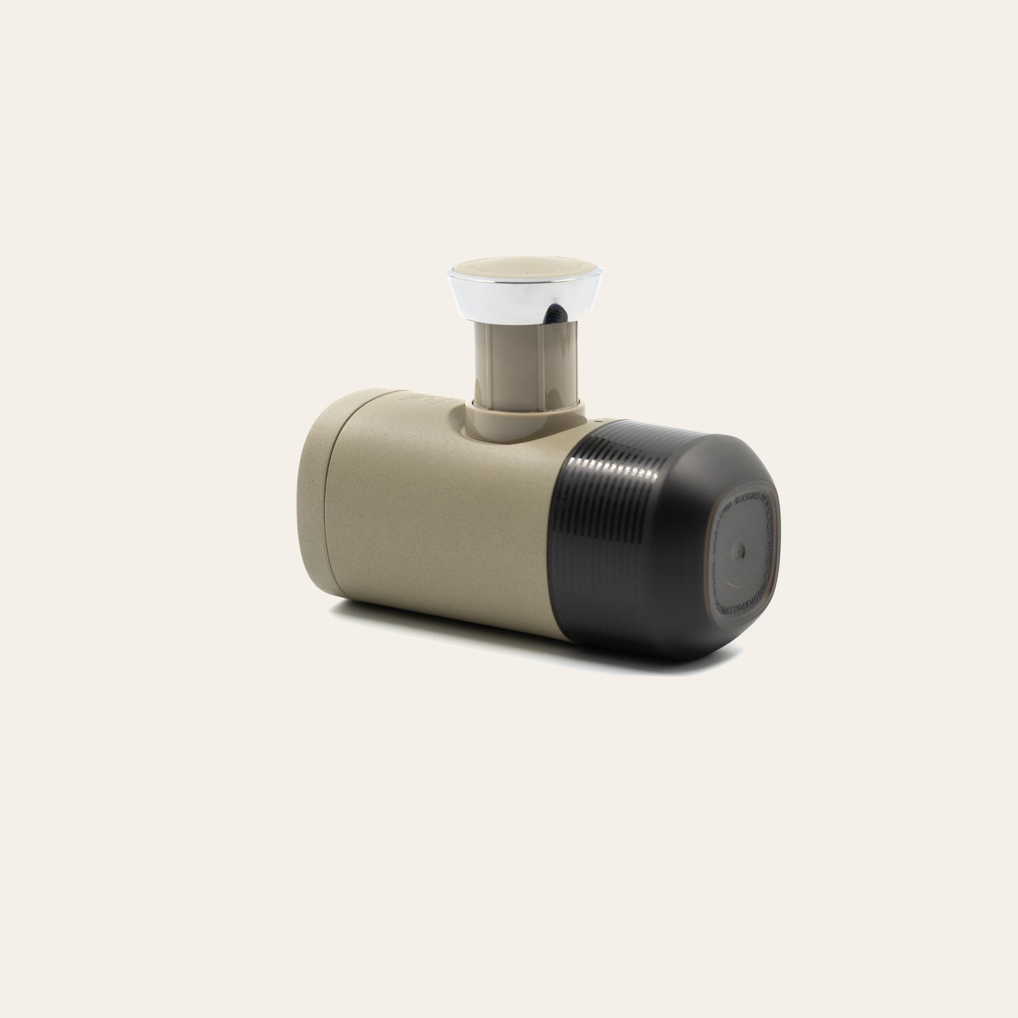 Minipresso laying on it's side with pump lever up on a beige background