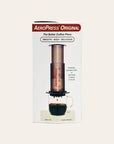 Aeropress Original coffee press packaging on a beige background