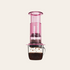 Pink AeroPress coffee maker brewing into a cup on a beige background