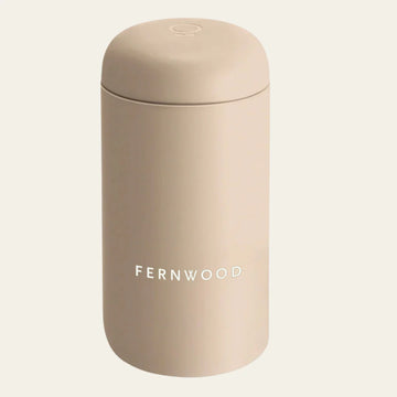 Beige travel mug with 'FERNWOOD' branding on a white background