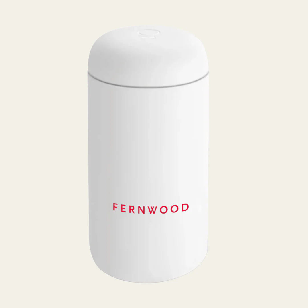White travel mug 'FERNWOOD' branding on a beige background