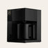 Black coffee maker in a box with a brand logo on a beige background
