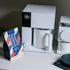 White coffee maker with a mug and Ethiopia coffee package on a gray kitchen surface