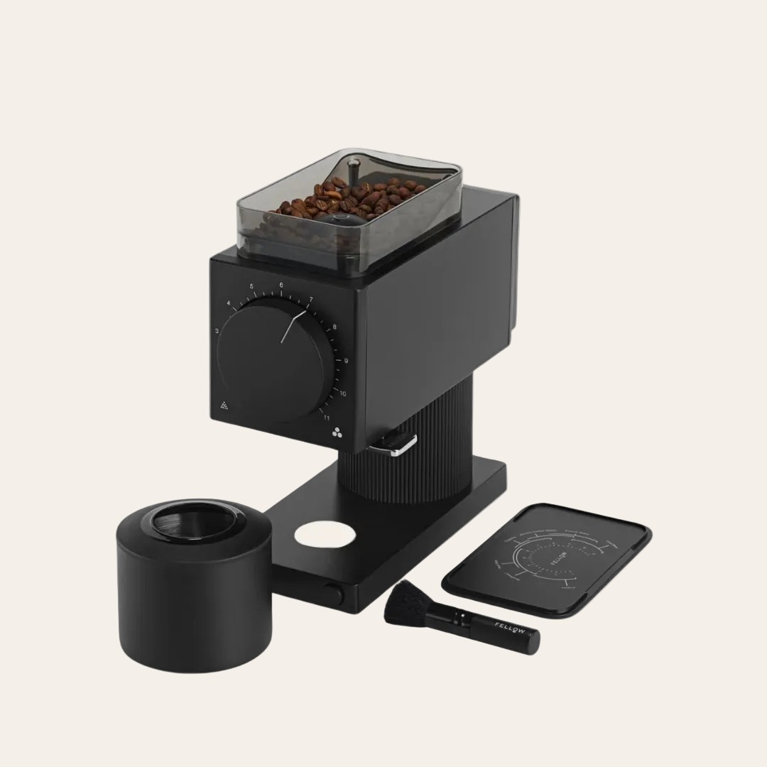 Fellow Ode coffee grinder with beans on a beige background