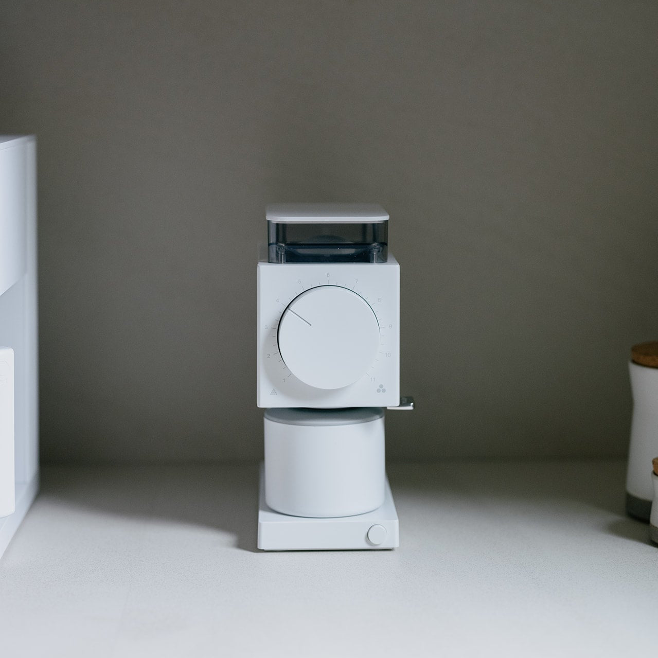 Fellow Ode coffee grinder on a gray surface with a neutral background