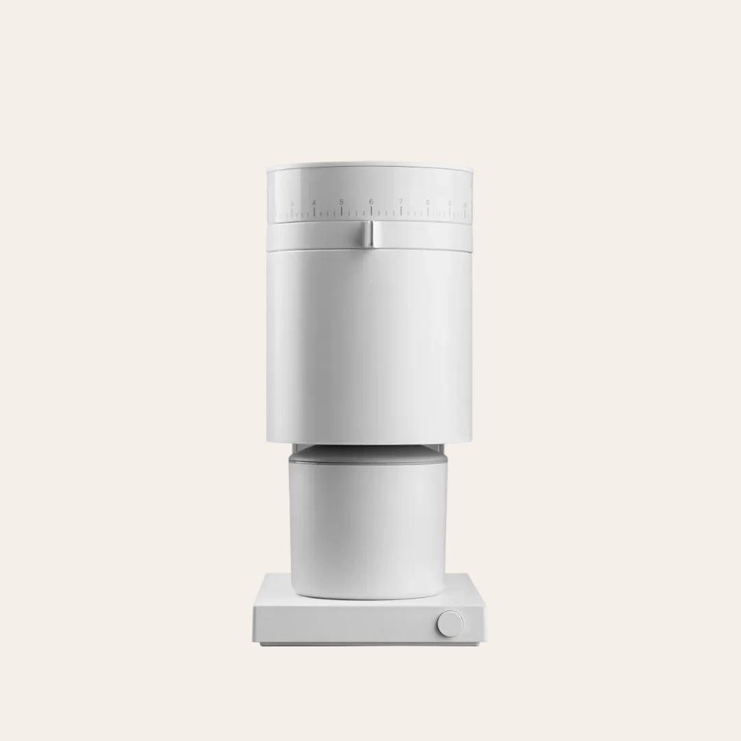 White coffee grinder with a dial on a beige background