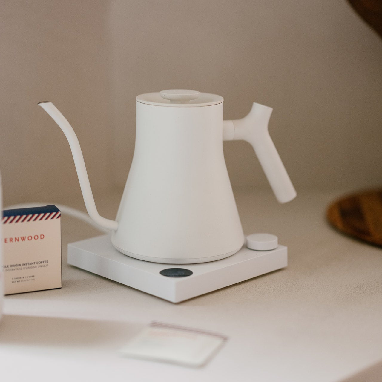 White kettle on a white surface with a neutral background