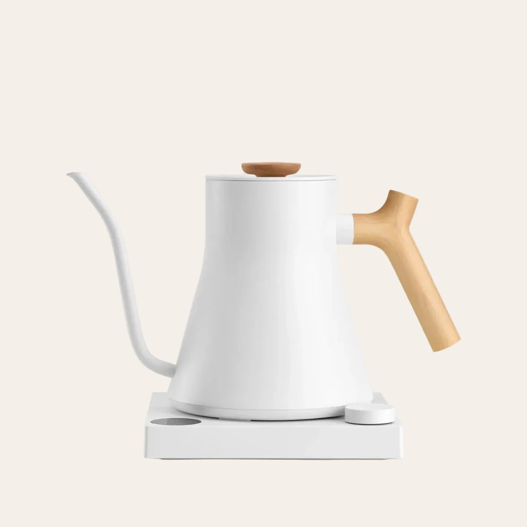 White electric kettle with a wooden handle on a light beige background