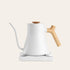 White electric kettle with a wooden handle on a light beige background