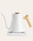 White electric kettle with a wooden handle on a light beige background