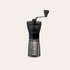 Black manual coffee grinder with crank lever-style handle.