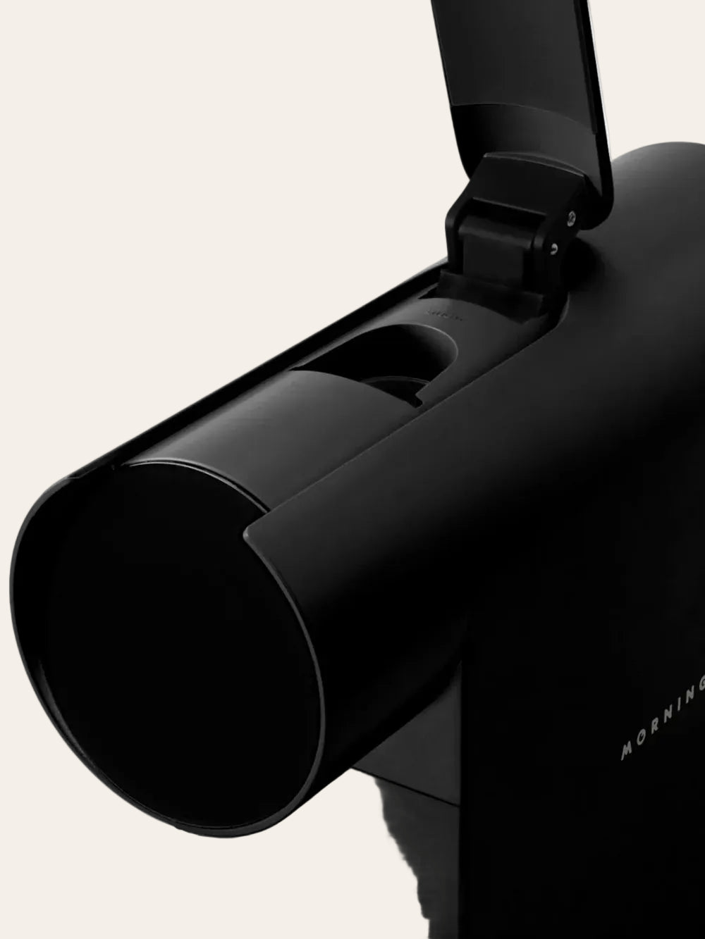 Close-up of a black espresso maker on a beige background