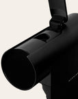 Close-up of a black espresso maker on a beige background