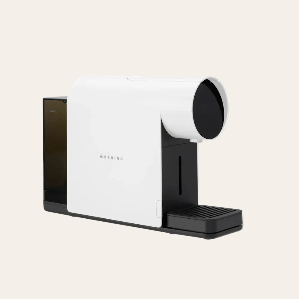 White and black coffee machine on a beige background