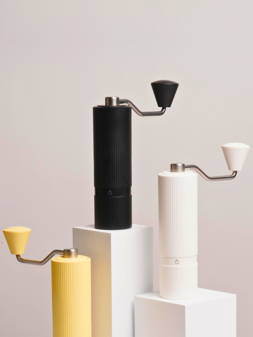 Nuttii Goosey hand grinders in black, off-white and yellow on white display blocks