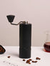 Black Nuttii Goosey hand grinder with coffee beans and a glass server