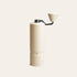 Off-white Nuttii Goosey hand coffee grinder with a fluted body and conical handle knob