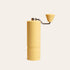 Yellow Nuttii Goosey hand coffee grinder with a fluted body and conical handle knob