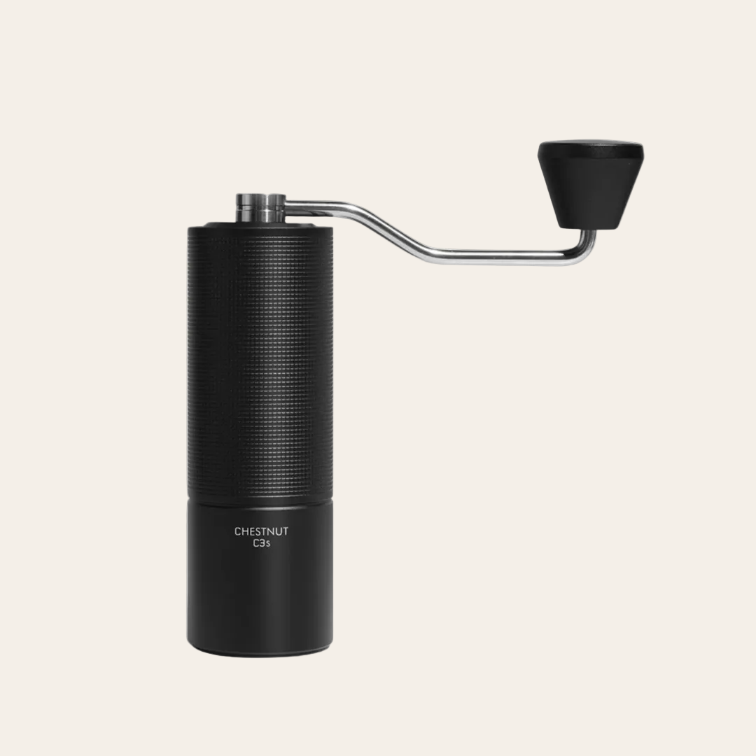 Black manual coffee grinder on beige background