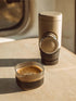 Portable espresso maker and a cup of coffee on a wooden surface
