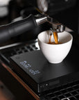 Digital coffee scale with espresso mug on it.