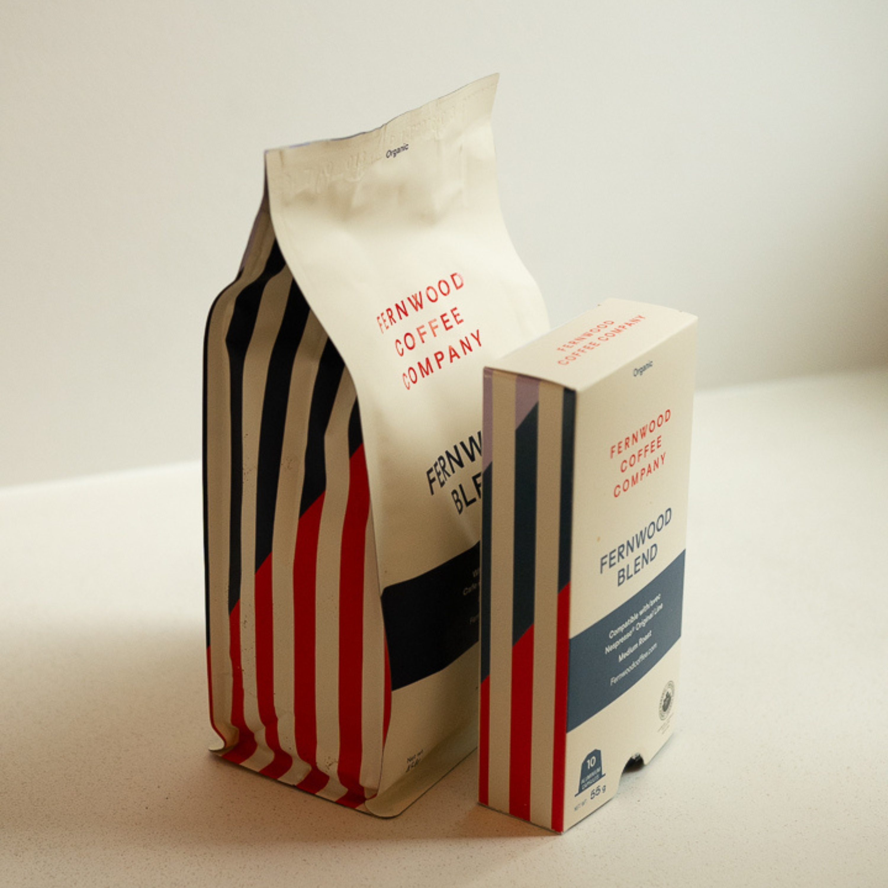 A bag of Fernwood Blend beans and a box of Fernwood Blend Capsules paired together on a white counter.