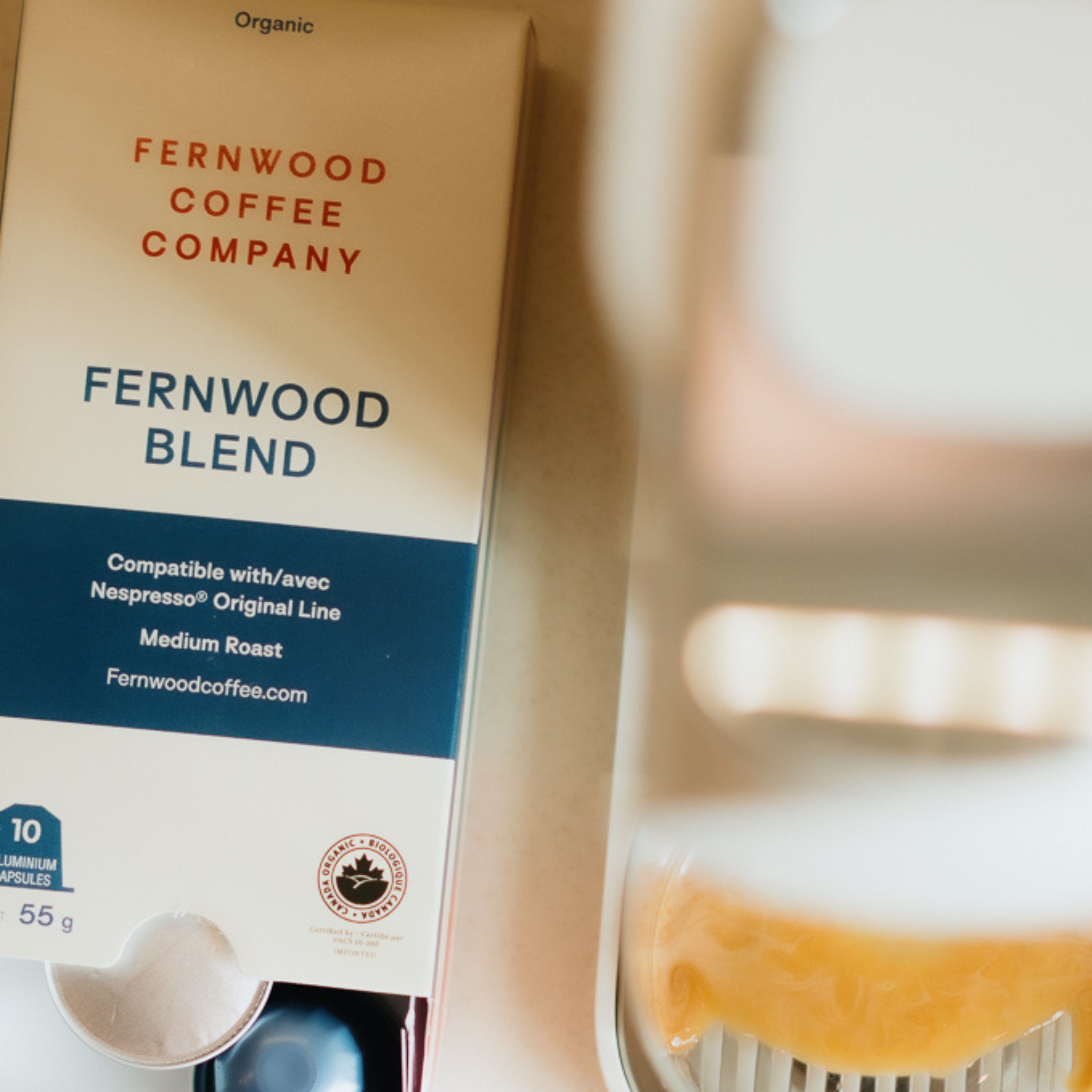 Fernwood Blend coffee capsule brewing packaging brewing a cup with a blurred background