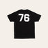 Back of a white tshirt with large 76 numbering in black on a beige background