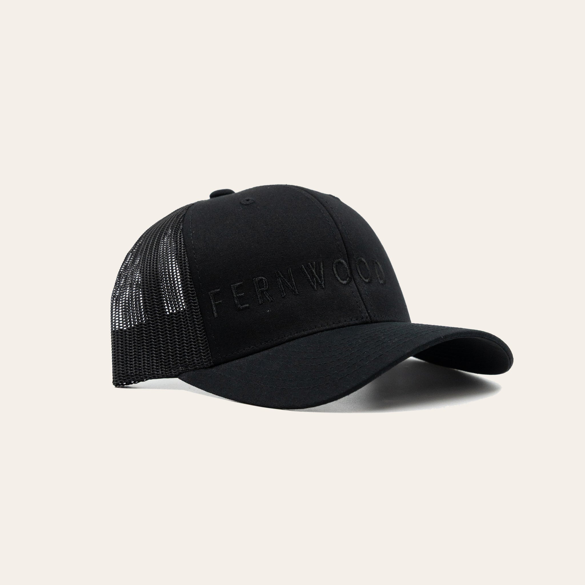Black cap with 'FERNWOOD' across the front on a beige background