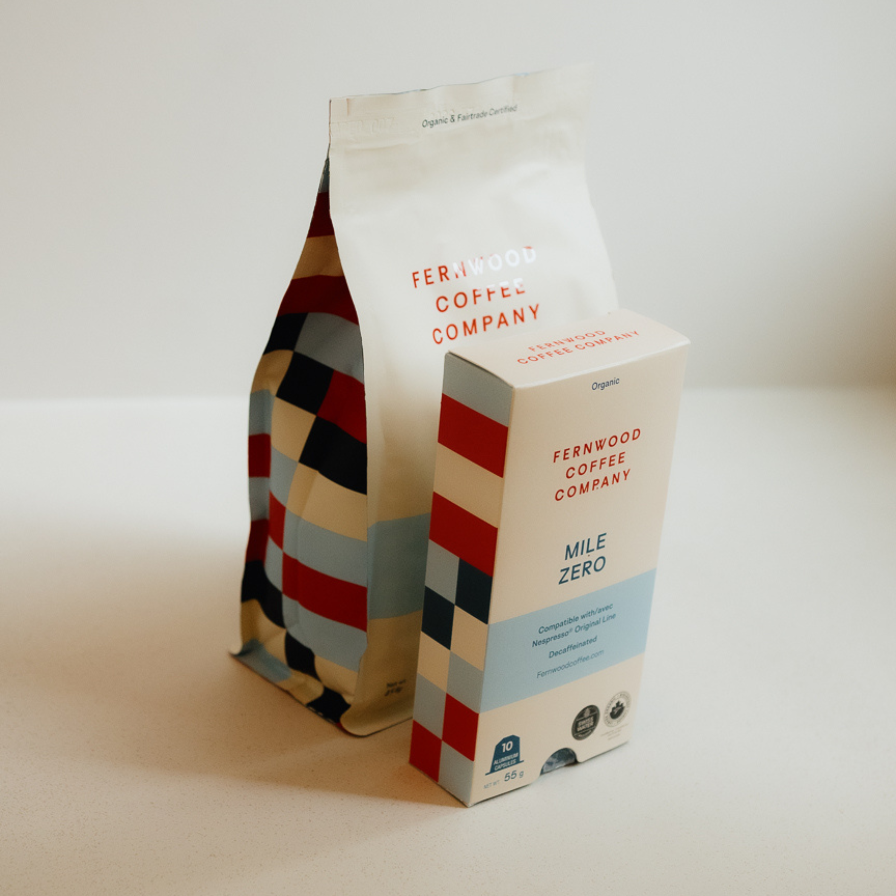 A bag of Mile Zero beans paired with a box of capsules on a white counter.