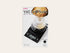 Hario V60 Drip Scale packaging with digital display and coffee brewing setup.