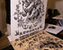 Rio pulling a completed print off the wooden stencil he hand carved